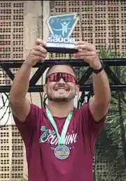 Raul celebrando uma prova com medalha e troféu
